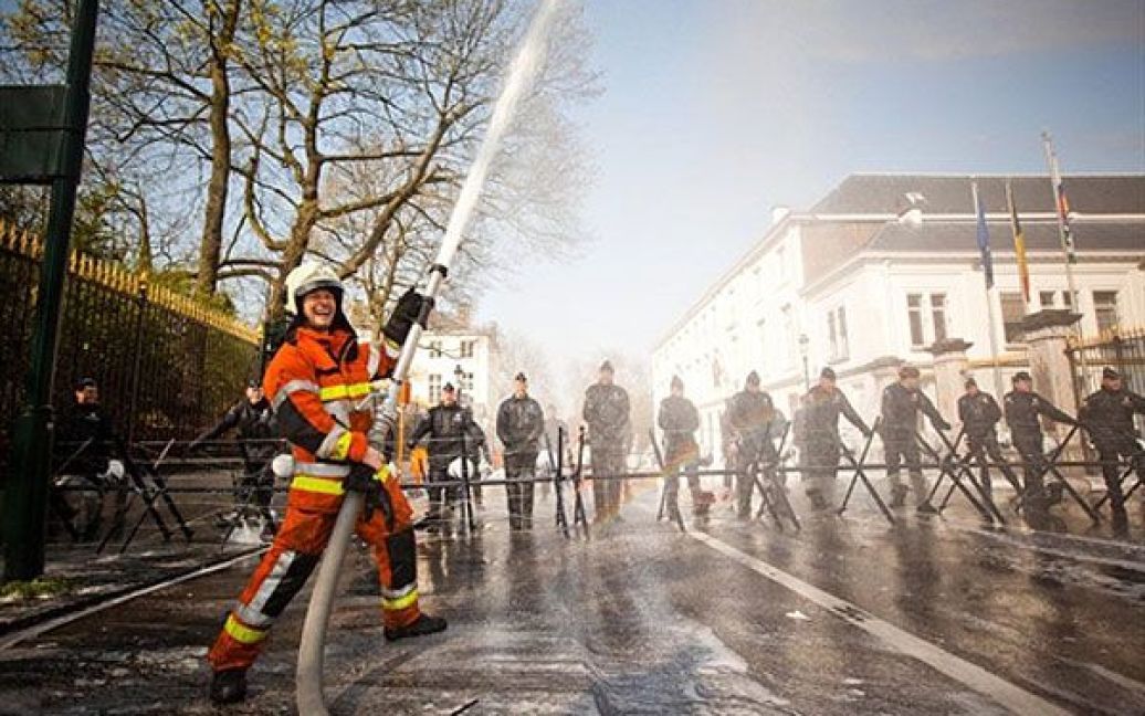 Бельгія, Брюссель. Пожежний жартує із пожежним рукавом під час демонстрації перед будівлею регіонального міністра Чарльза Піке в Брюсселі. / © AFP