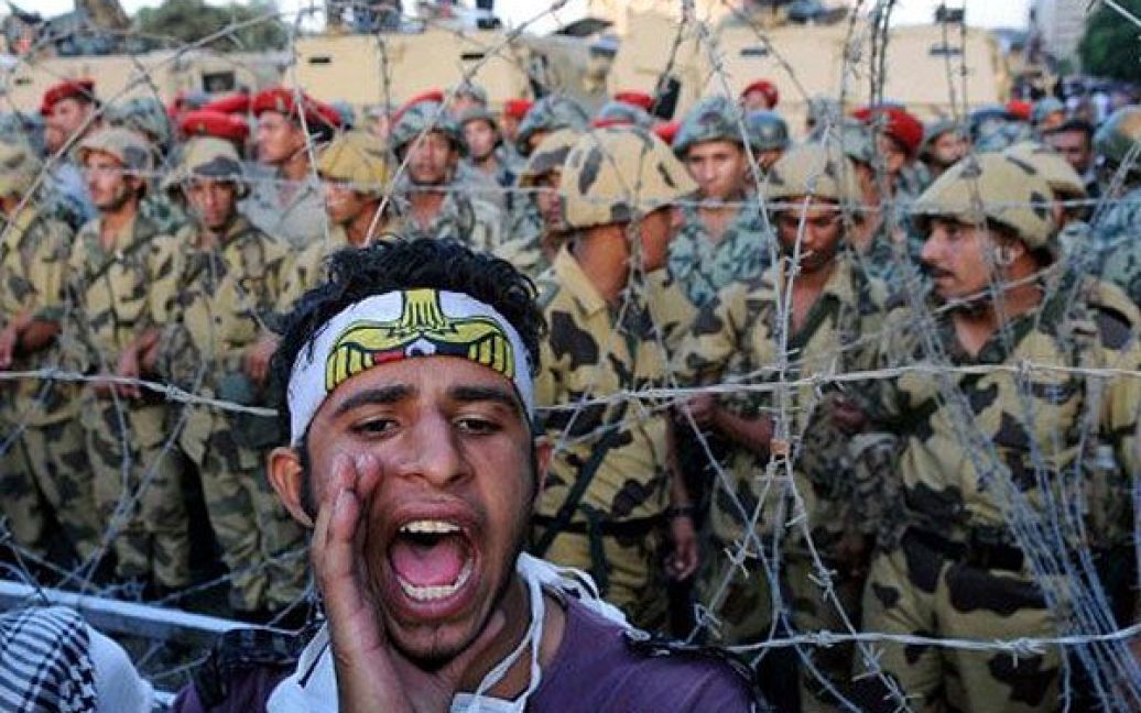 Єгипет, Каїр. Єгипетські солдати стоять на варті за колючим дротом під час акції протесту перед міністерством оборони та штабом Верховної Ради Збройних Сил в Каїрі. Демонстранти висловили невдоволення владою військових. / © AFP