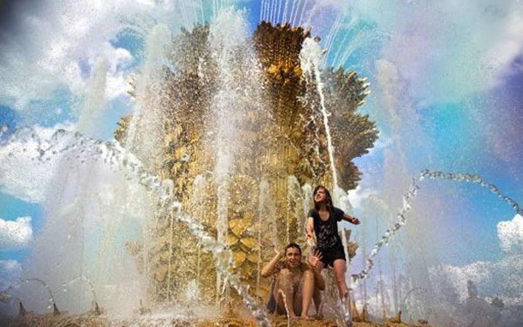 Росія, Москва. Російські підлітки охолоджуються у фонтані в Москві, де температура повітря сягла 27 градусів за Цельсієм. / © AFP