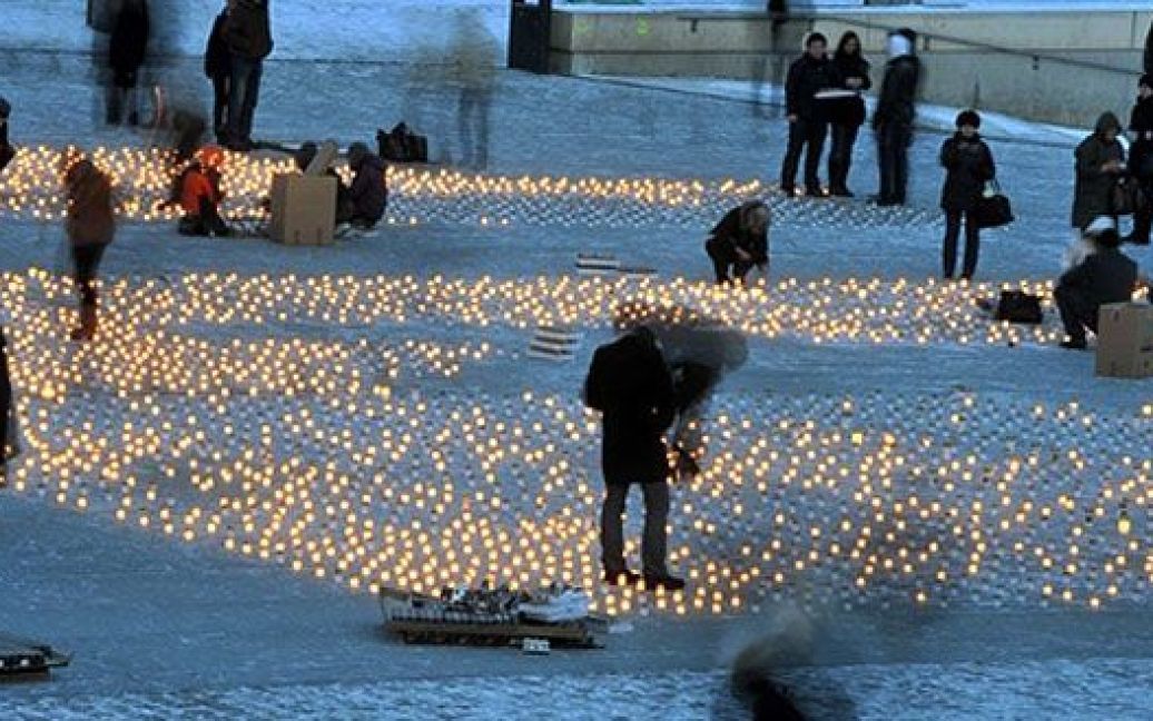 Естонія, Таллінн. Люди запалюють свічки під час меморіальної акції на честь естонців, яких депортували до Сибіру після вторгнення СРСР в естонію у 1949 році. / © AFP