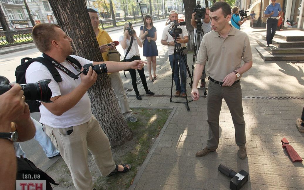 Працівник посольства Грузії почав заважати фотографувати акцію протесту FEMEN, руками бив по фотокамерах журналістів. / © 