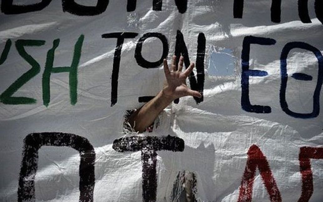 Греція, Афіни. Демонстрант жестикулює під час акції протесту проти нових жорстких заходів економії в Афінах. / © AFP