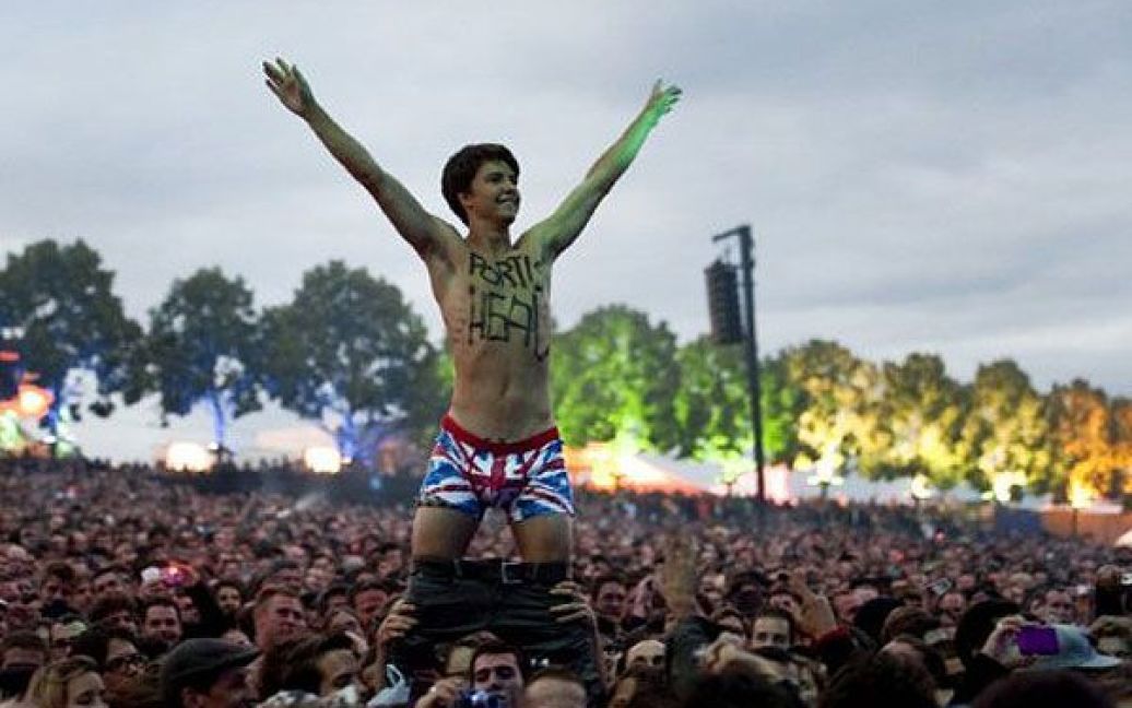 Швейцарія, Ньоні. Глядач вітає британську групу Portishead під час їхнього виступу на 36-му фестивалі Палео в місті Ньоні. Палео є одним з найбільших в Європі музичним фестивалем, який проходить просто неба. / © AFP