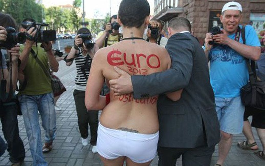 Співробітник служби безпеки відвів активістку FEMEN / © УНІАН