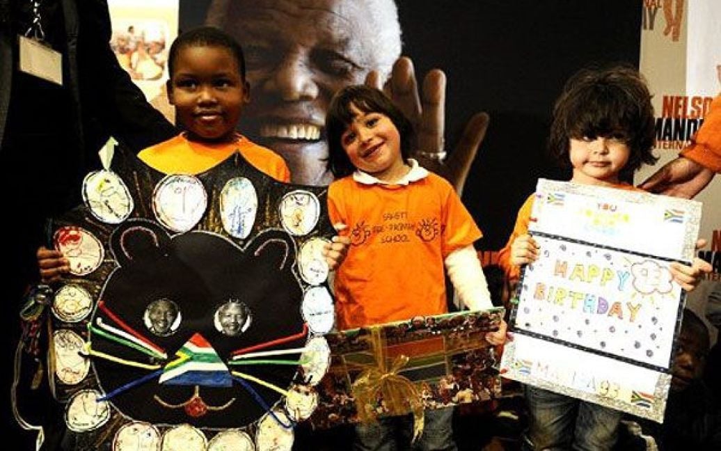ПАР, Йоганнесбург. Школярі тримають вітальні листівки під час церемонії вітання Нельсона Мандели з дев&#039;яносто третім днем народження. / © AFP