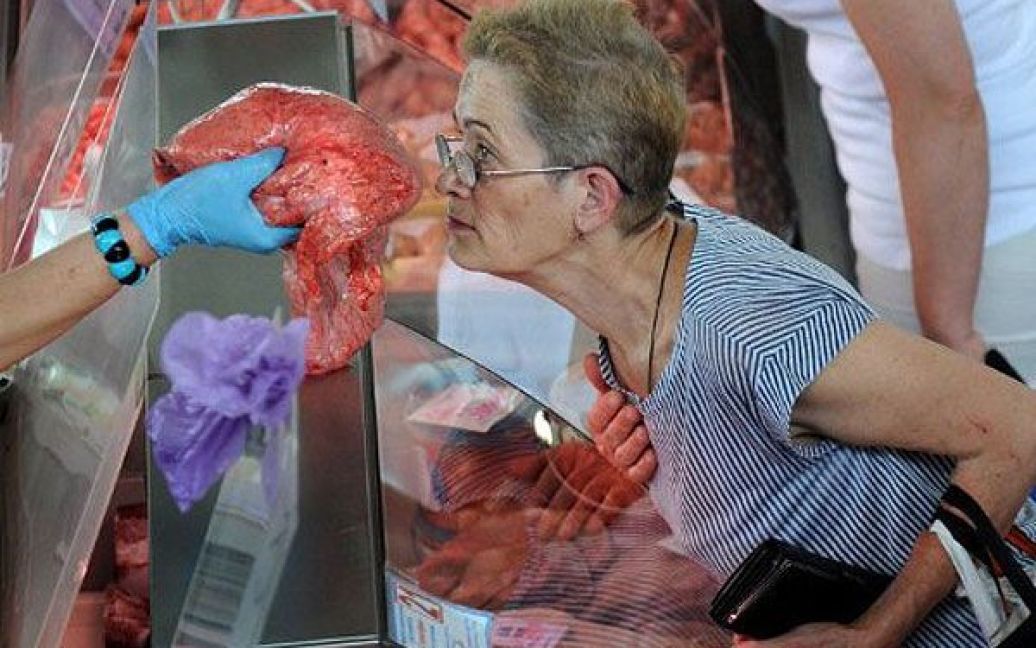 Білорусь, Мінськ. Жінка нюхає шматок м&#039;яса на ринку в Мінську. Споживчі ціни в Білорусі зросли на 36,2% з початку року. В країні зафіксовано найвищий рівень інфляції за останє десятиліття. / © AFP