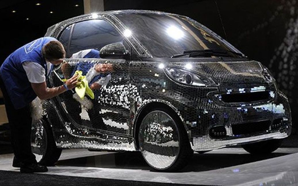 США, Нью-Йорк. Працівник вимиває дзеркальний електромобіль Smart, який був презентований на Нью-Йоркському міжнародному автосалоні 2011 у центрі Jacob Javits Convention. / © AFP