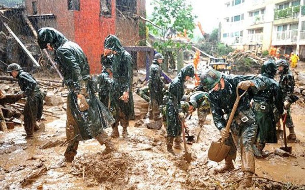Республіка Корея, Сеул. Південнокорейські солдати прибирають тонни бруду після повені, викликаної проливними дощами в Сеулі. Десятки тисяч людей постраждали від "дощів століття" та руйнівних зсувів, загинули щонайменше 39 осіб, затоплені сотні будинків. / © AFP