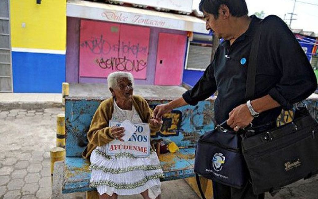 Нікарагуа, Манагуа. 105-річна Корнелія Гомес сидить на автобусній зупинці з табличкою "Мені 105 років, допоможіть мені". Гомес, яка є однією з найстаріших людей планети, жебракує на вулиці протягом восьми років, сподіваючись, що уряд допоможе їй. / © AFP