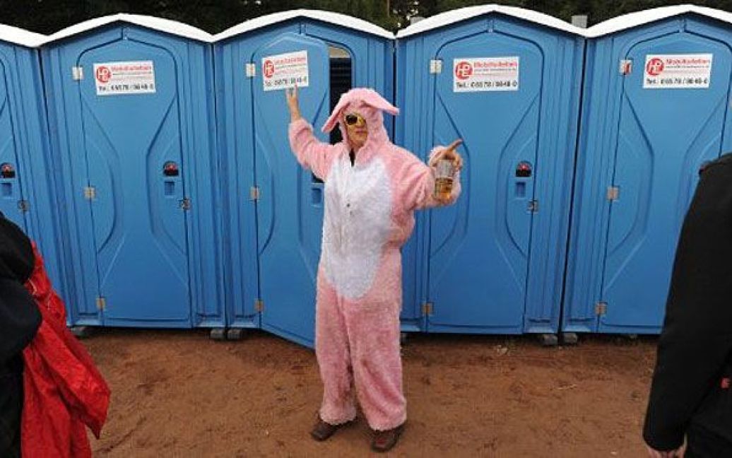Німеччина, Шессель. Жінка у костюмі кролика намагається сховатися в туалеті від урагану, який почався під час фестивалю в місті Шессель, північна Німеччина. У триденному музичному фестивалі беруть участь близько 80 гуртів, послухати які приїхали 73 000 меломанів. / © AFP