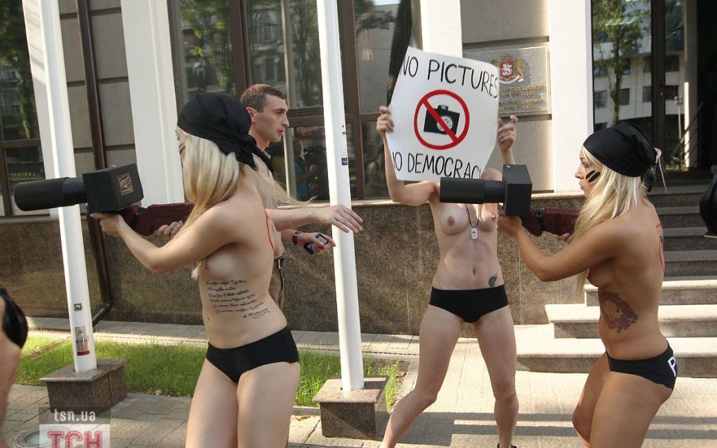 Коли оголені активістки FEMEN із саморобними паперовими "фотокамерами" з&rsquo;явились перед будівлею посольства, працівник посольства почав заважати фотографувати акцію протесту / © 