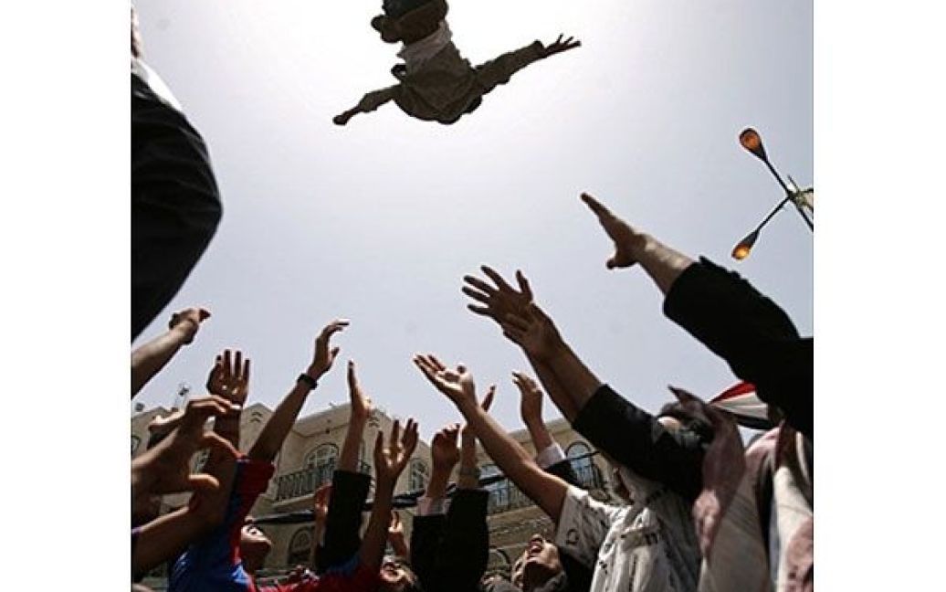 Ємен, Сана. Єменські антиурядові демонстранти підкидають у повітря юнака під час демонстрації з вимогою відставки президента Ємену Алі Абдалли Салеха в Сані. / © AFP
