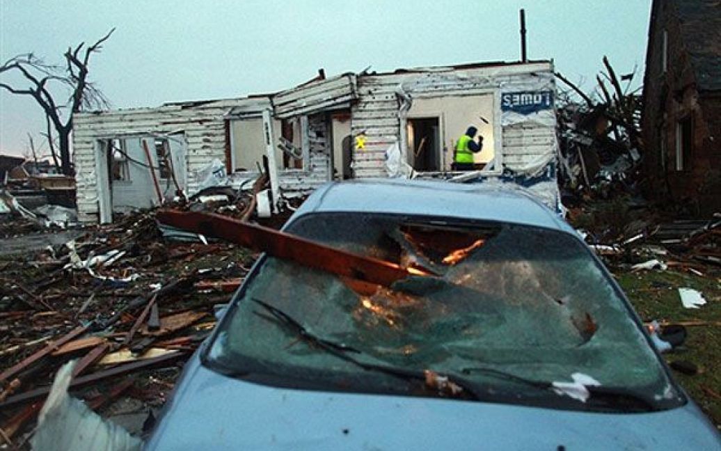 США, Джоплін, штат Міссурі. Рятувальник роздивляється залишки будинку, зруйнованого під час смертельного торнадо, який обрушився на Середній Захід США. В результаті торнадо, 116 осіб загинули, було стерто з обличчя Землі місто Джоплін у штаті Міссурі. / © AFP