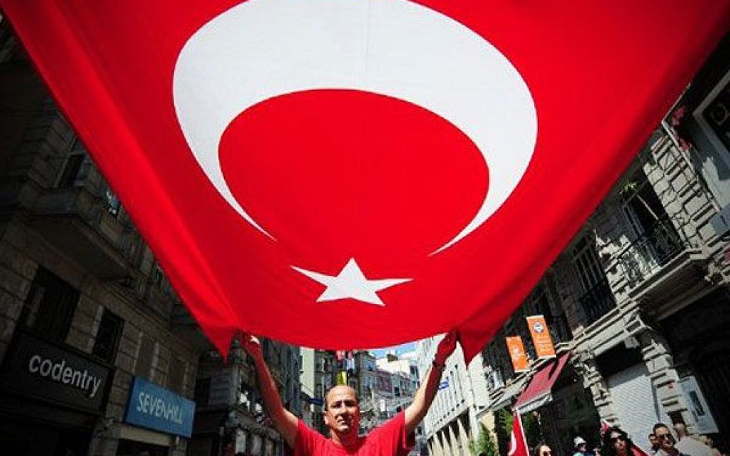 Туреччина, Стамбул. Турок тримає національний прапор під час демонстрації в Стамбулі, учасники якої засудили акти насильства курдських сепаратистів, що призвели до загибелі 13 турецьких солдатів. / © AFP