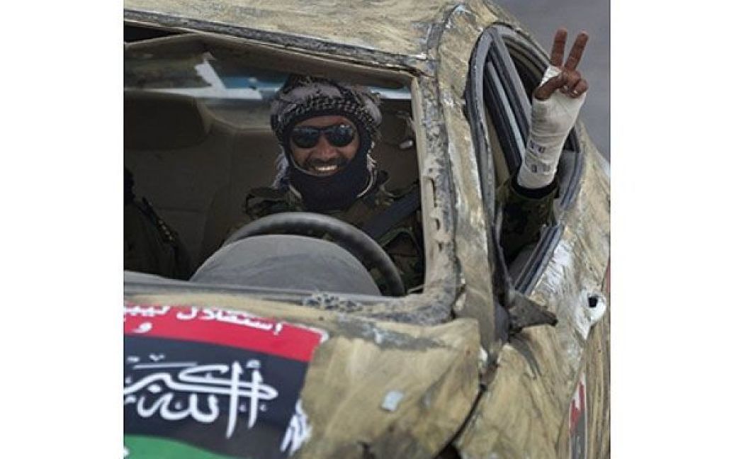 Лівійська Арабська Джамахірія, Аждабія. Лівійський повстанець показує знак перемоги, сидячи у автомобілі поблизу з лінією фронту у місті Аждабія. / © AFP