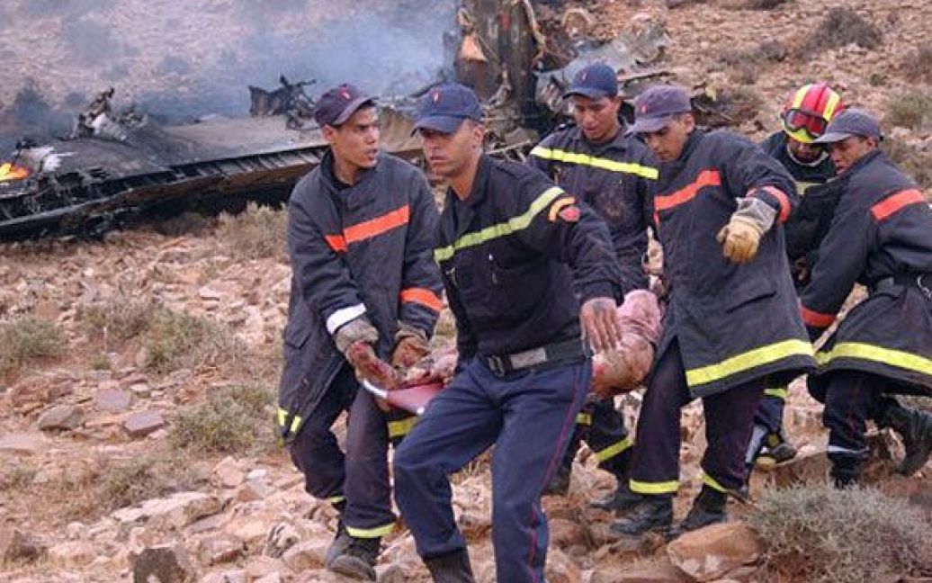 Марокко, Гулмім. Рятувальники несуть тіло людини, яка загинула в результаті падіння літака на півдні Марокко. Військово-транспортний літак Геркулес С-130 врізався в гору через погану погоду, загинули всі 80 осіб, що перебували на борту. / © AFP