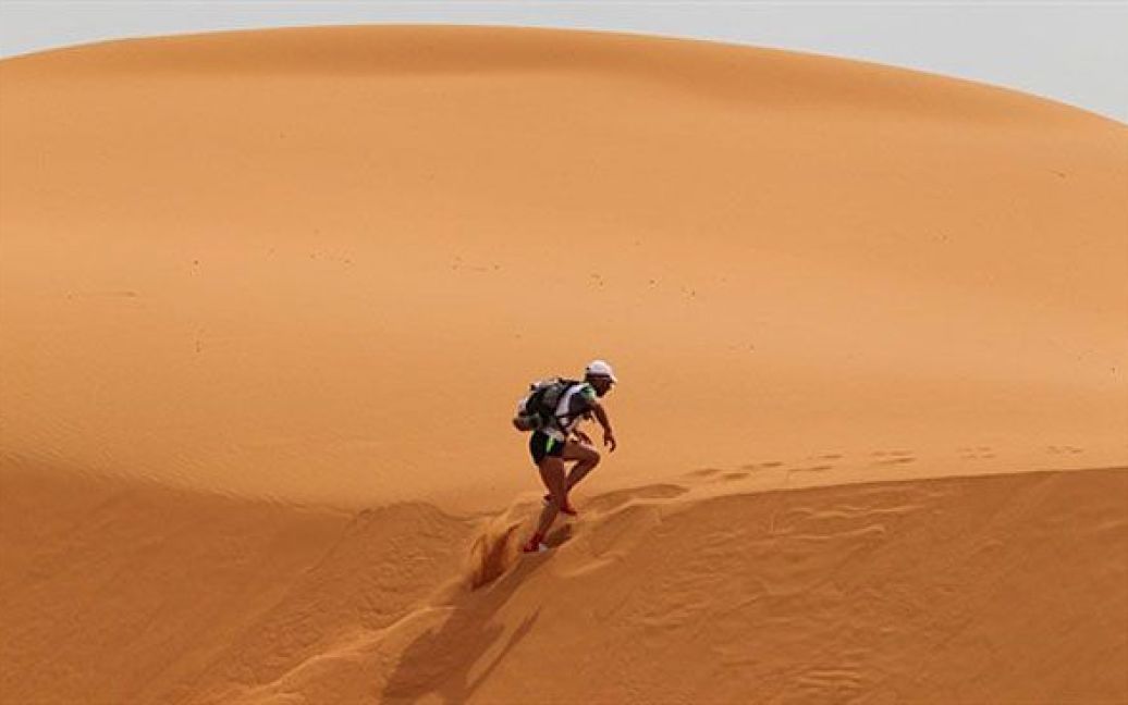 Марокко. Учасник змагань перетинає найвищі у Марокко дюни Мерзуга під час 26-го "Пустельного марафону". Протягом семми днів 844 учасники марафону мають подолати пішки 250 км марокканською Сахарою. / © AFP