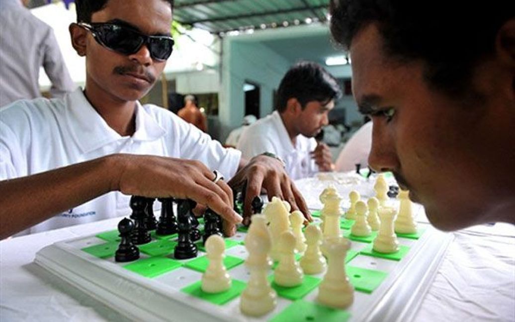 Індія, Хайдарабад. Індійські шахісти, зір яких обмежено, грають під час Всеіндійського шахового турніру, який провели в школі для сліпих "Девнар" у Хайдарабаді. В турнірі беруть участь близько 118 людей з ослабленим зором з 12 штатів Індії. / © AFP