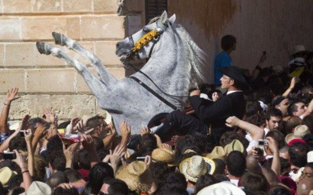 Іспанія, Сьютаделла. Кінь стає на цапа у натовпі під час святкування традиційного фестивалю Святого Іоанна на Балеарських островах. / © AFP