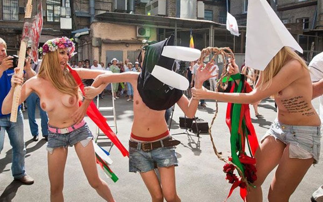 Оголені дівчата з руху FEMEN у ковпаку ката та з макетом сокири в руках почали імітувати страту з криками "Забій кролятини". / © 