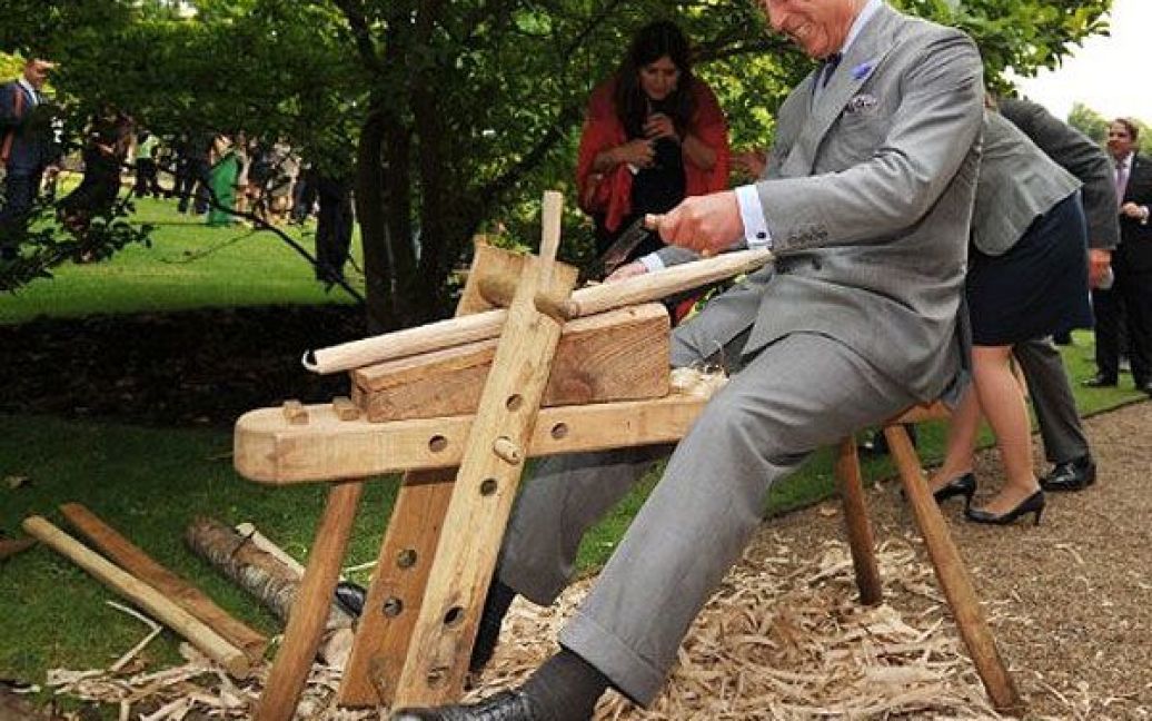 Великобританія, Лондон. Британський принц Чарльз вирізає з дерева під час візиту на виставку Start Garden Exhibition and Pop-Up Restaurant в Кларенс-Хаусі в центрі Лондона. / © AFP