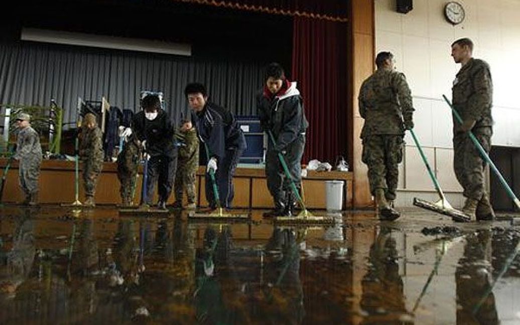 Японія, Ісіномакі. Американські солдати та учні миють підлогу в гімназії міста Ісіномакі. / © AFP