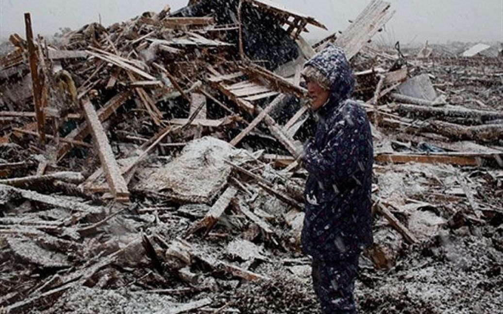 Японія, Нода. 74-річна Юкіко Комета стоїть перед совїм будинком, зруйнованим під час цунамі. Японія потерпає від наслідків руйнівних землетрусів та цунамі, які стали найгіршим в історії країни лихом з часів Другої Світової війни. / © AFP