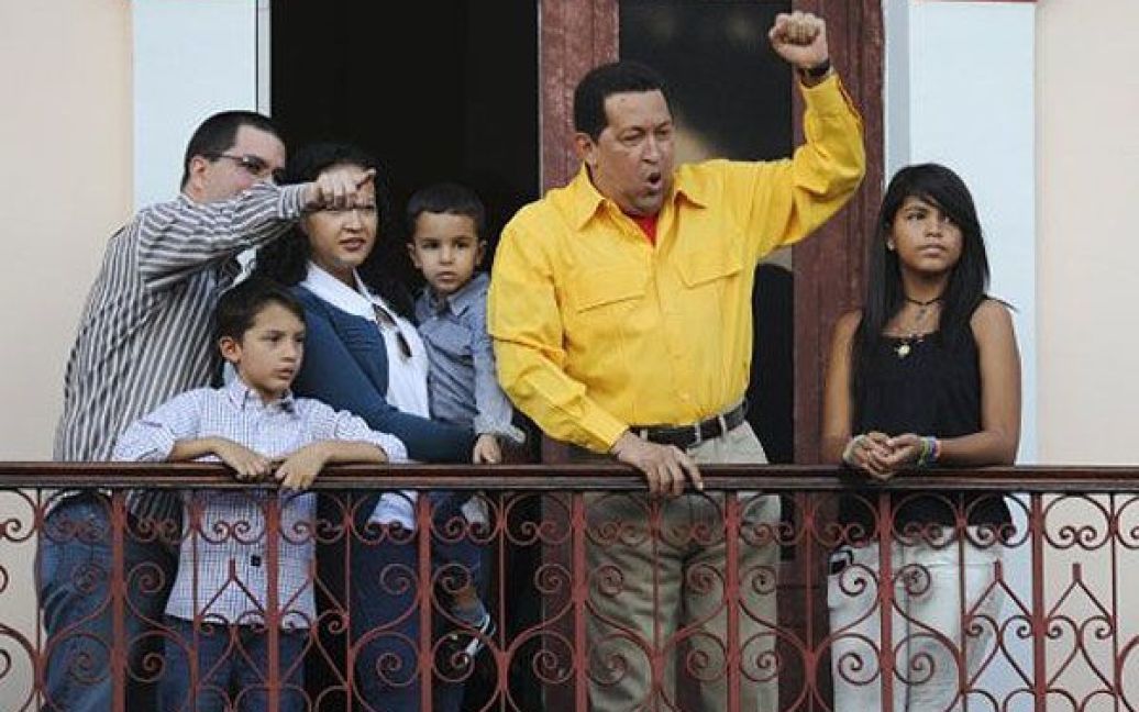 Венесуела, Каракас. Президент Венесуели Уго Чавес в оточенні членів своєї родини вітає людей з балкона президентського палацу Мірафлорес в Каракасі. Уго Чавес відсвяткував свій 57-й день народження і пообіцяв остаточно подолати хворобу, щоб стати президентом на виборах у 2012 році. / © AFP