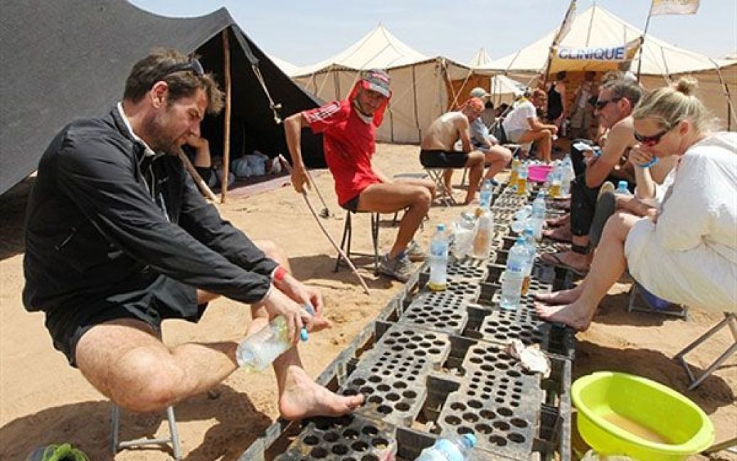 Марафонці отримують медичну допомогу перед останнім етапом Піщаного марафону. / © AFP
