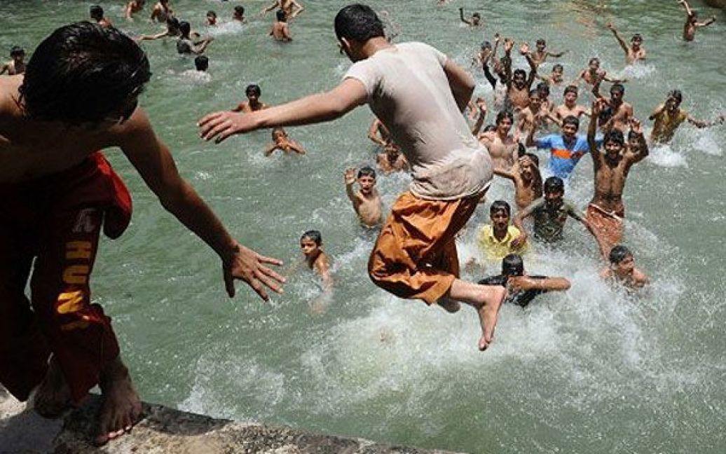 Пакистан, Лахор. Пакистанська молодь стрибає в басейн під час спекотного дня в Лахорі. Пакистанський Метеорологічний департамент прогнозує, що найближчим часом температура сягне 40 градусів за Цельсієм. / © AFP