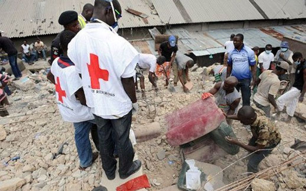 Нігерія, Лагос. Працівники рятувальної команди Червоного Хреста розбирають завали на місці, де обрушилась чотириповерхова будівля. Підтверджено загибель шістьох осіб, під завалами ще лишаються люди. / © AFP