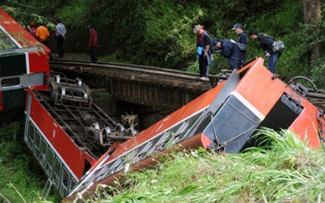 Тайвань, Алішан. Слідчі оглядають потяг, що зійшов з колії на гірському перевалі поблизу Алішана. Аварія сталася через падіння дерева на колію. В результаті аварії загинули щонайменше 5 людей. / © AFP