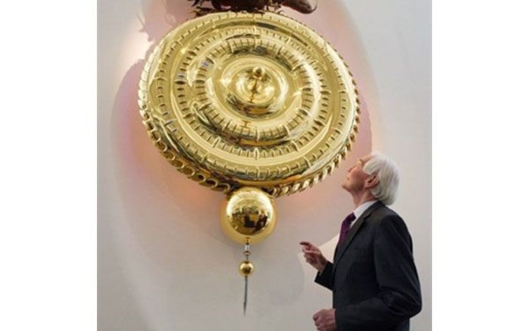 Великобританія, Лондон. Доктор Джон Тейлор позує з годинником "Годинник, що їсть час &mdash; історія винаходу" в Музеї науки в Лондоні. На створення годинника пішло два роки. Згори на годиннику сидить міфічна істота, що пожирає секунди. / © AFP