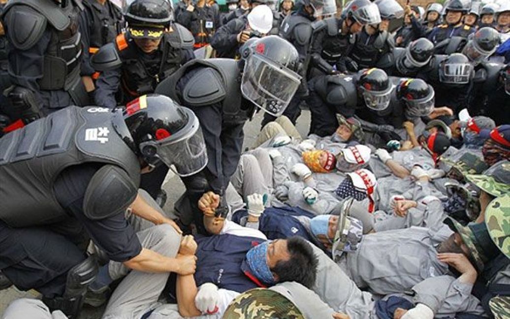 Республіка Корея. Південнокорейський спецназ прориває блокаду страйкуючих перед головним заводом підприємства Yoosung поблизу Сеула. Близько 500 робітників були затримані. / © AFP
