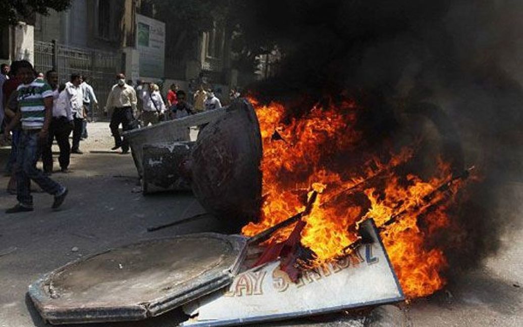 Єгипет, Каїр. Єгипетські демонстранти підпалили рекламний щит перед міністерством внутрішніх справ в центрі Каїра. В результаті кривавих зіткнень між протестуючими і поліцією, які спалахнули на площі Тахрір у Каїрі, сотні людей отримали поранення. / © AFP