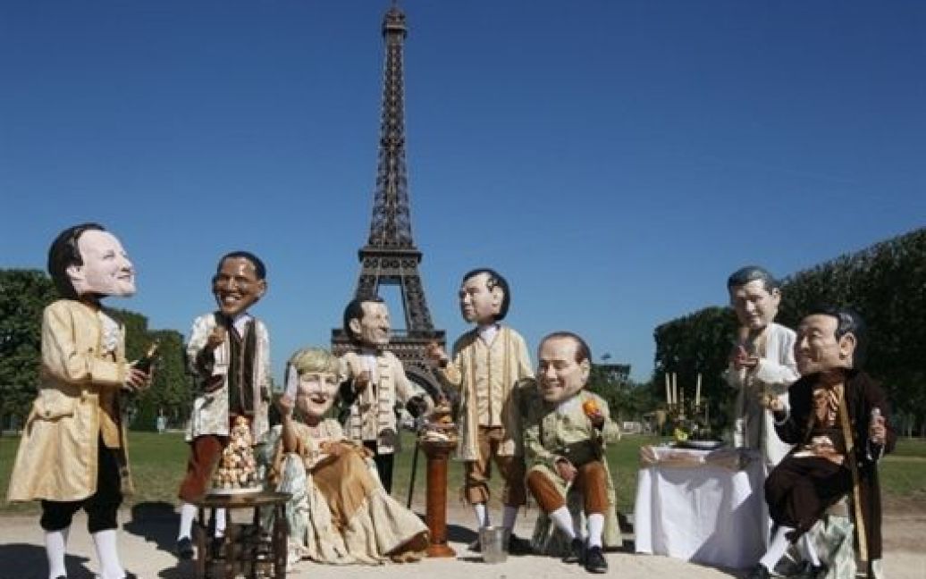 Франція, Париж. Активісти у гігантських костюмах лідерів G8 зібрались перед Ейфелевою вежею в Парижі напередодні майбутньої зустрічі G8 у Довілі. / © AFP