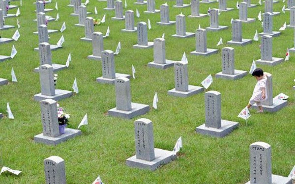 Республіка Корея, Сеул. Південнокорейська дівчинка віддає пошану під час відвідування національного кладовища на День пам&rsquo;яті в Сеулі. Південна Корея відзначила 56-ту річницю пам&rsquo;яті жертв корейської війни 1950-53 рр. / © AFP