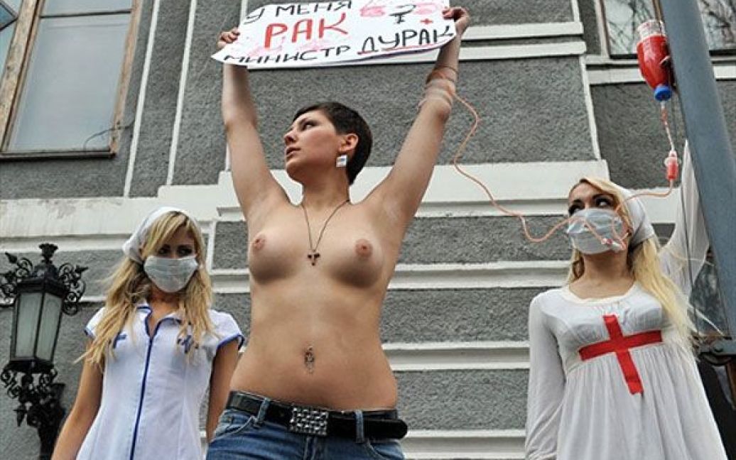 Активістка FEMEN протестувала топлес з плакатами "Я помираю, а ви крадете!", "Епідемія раку совісті", "Momento mori, Yemets!" і "У мене рак, міністре дурак". / © AFP