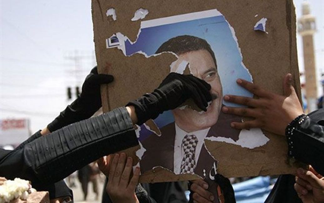 Ємен, Сана. Єменські антиурядові демонстранти розривають плакат із портретом президента країни Алі Абдалли Салеха під час демонстрації, що закликає до повалення Салеха. / © AFP