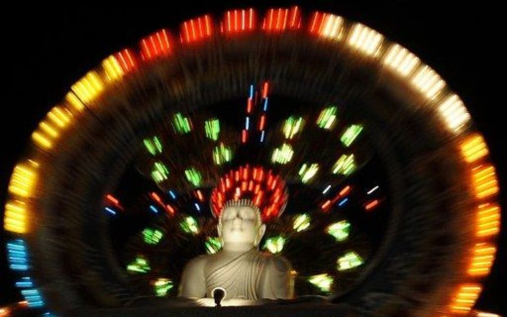 Шрі-Ланка, Коломбо. Гігантська статуя сидячого Будди, підсвічена на честь святкування Дня Тесак у Коломбо. Буддійське свято День Тесак відзначає народження, просвітлення і відход Будди. / © AFP