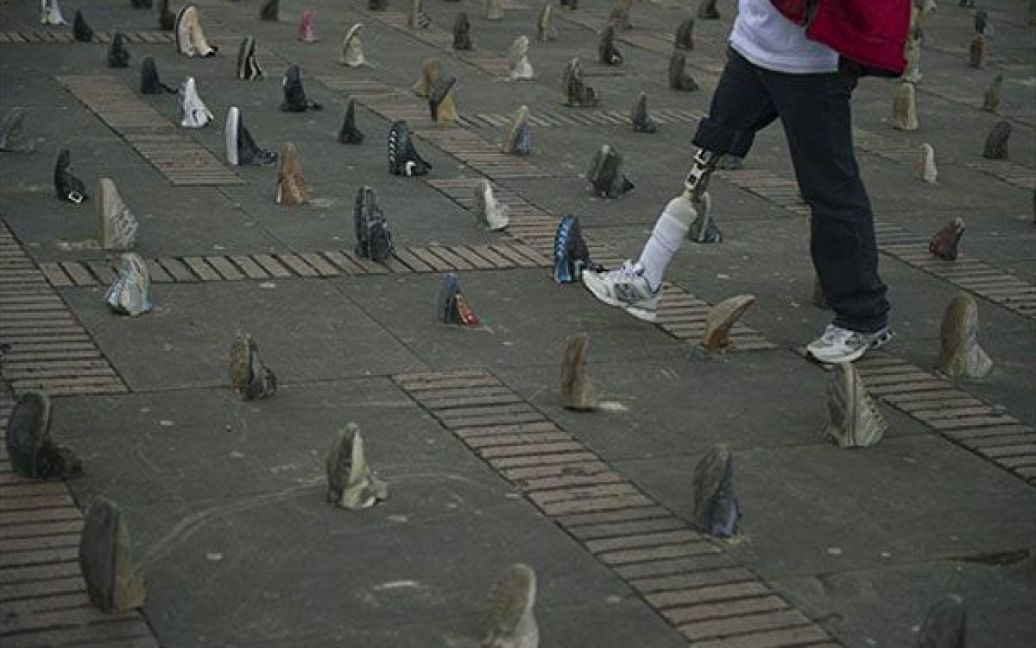 Колумбія, Богота. Жертва протипіхотної міни гуляє серед взуття, виставленого на площі Болівара у Боготі, на честь людей, які постраждали від мін у Колумбії. У світі провели Міжнародний день ООН за інформування про мінну небезпеку. / © AFP
