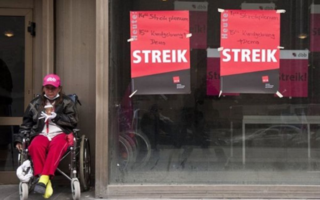 Німеччина, Берлін. Жінка у інвалідному візку сидить біля зачинених дверей госпіталю Charite Mittе. Більше 10 тисяч медичних співробітників оголосили страйк з вимогою підняти зарплати до 300 євро на місяць. / © AFP