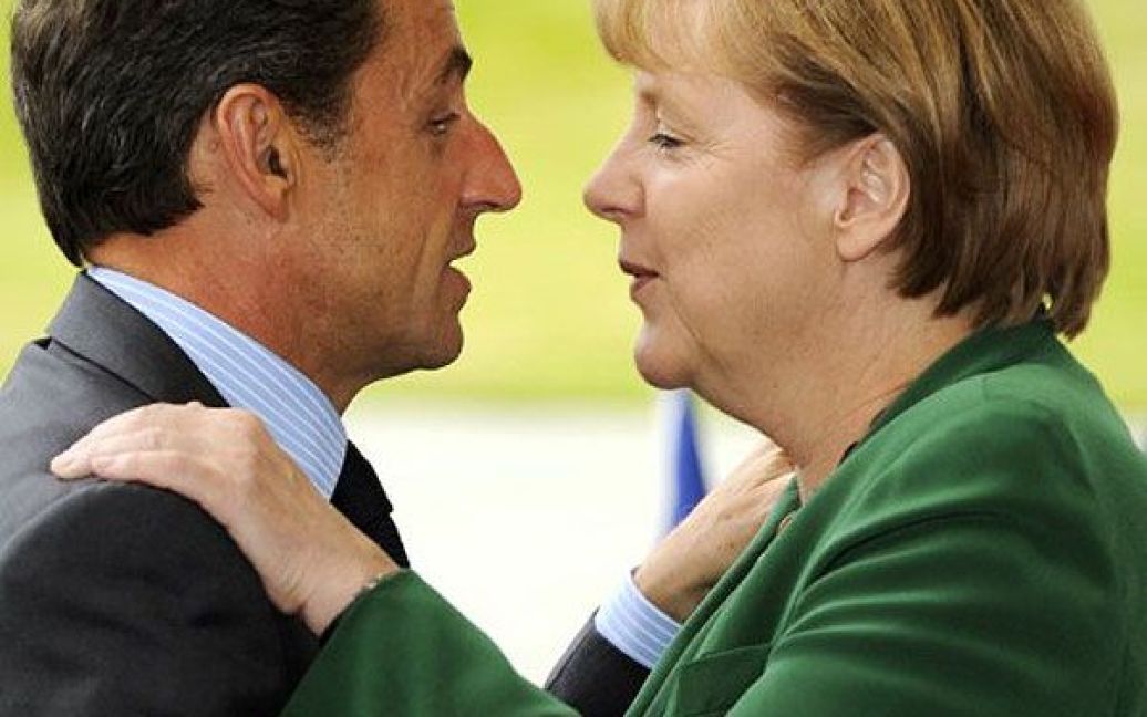 Німеччина, Берлін. Федеральний канцлер Німеччини Ангела Меркель вітає президента Франції Ніколя Саркозі у дворі канцелярії напередодні ключового саміту глав держав і урядів у Брюсселі. Учасники саміту розглядатимуть питання проблем економіки Греції. / © AFP