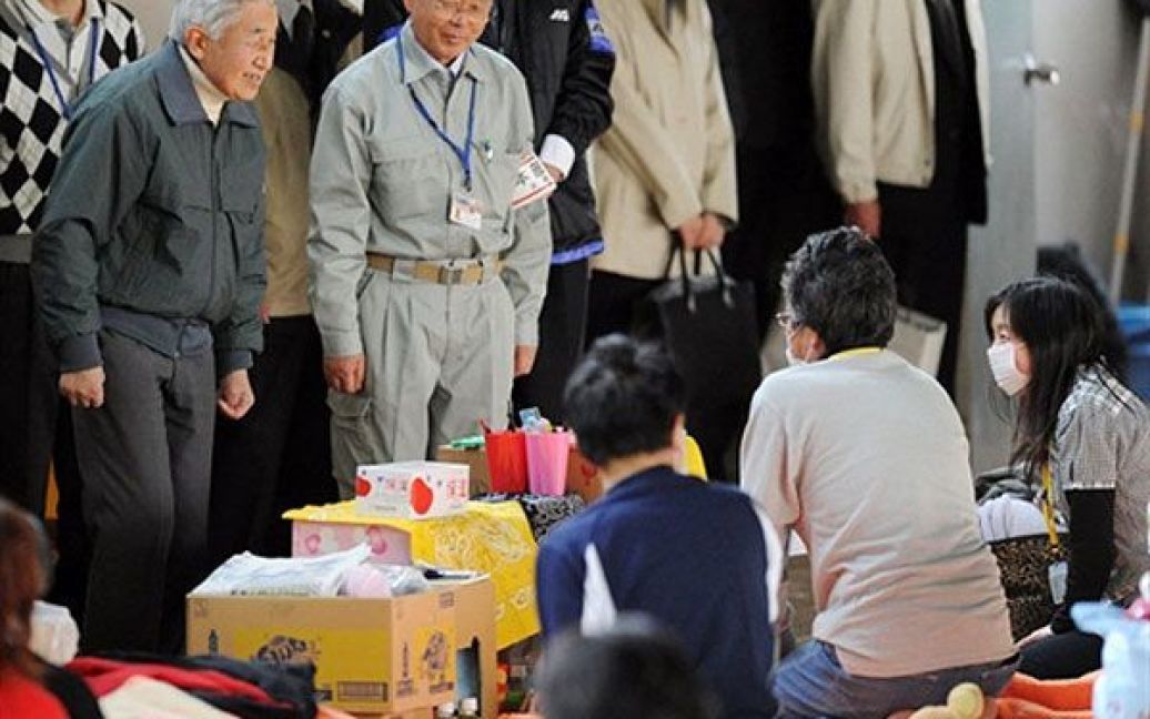 Японія, Казо. Японський імператор Акіхіто і мер міста Футаба Катсутака Ідогава спілкуються з людьми, які були евакуйовані з префектури Фукусіма, у колишній будівлі школи, де наразі мешкають більше тисячі жителів міста. / © AFP