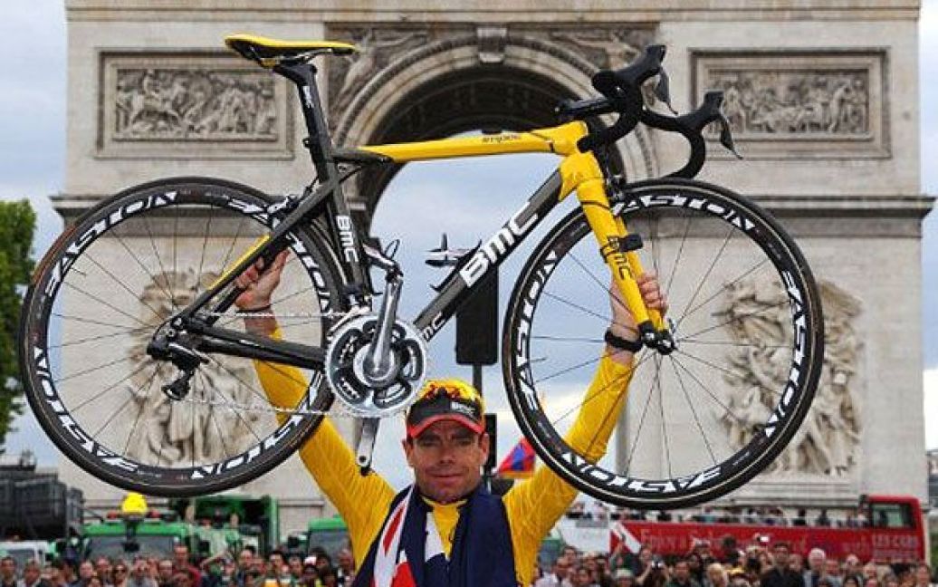 Франція, Париж. Австралійський велогонщик Кадель Еванс тримає жовту майку загального лідера велогонки, стоячи перед на своєму велосипеді перед Тріумфальною аркою на Єлисейських Полях в Парижі. Австралієць виграв велогонку "Тур де Франс 2011". / © AFP
