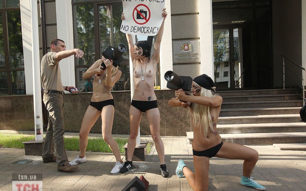 Коли оголені активістки FEMEN із саморобними паперовими "фотокамерами" з&rsquo;явились перед будівлею посольства, працівник посольства почав заважати фотографувати акцію протесту / © 
