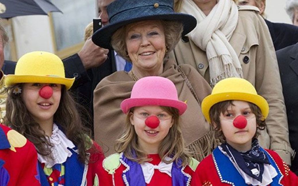 Німеччина, Берлін. Королева Нідерландів Беатрікс позує з дітьми у костюмах клоунів під час візиту на цирковий семінар для школярів у Берліні. / © AFP