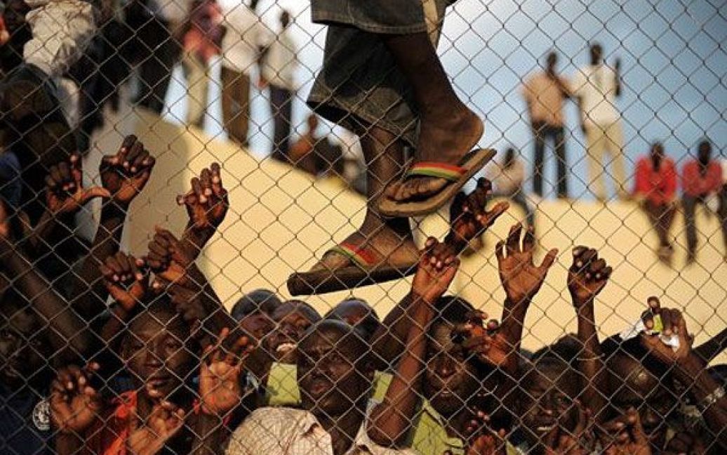 Судан, Джуба. Натовп футбольних глядачів намагається зазирнути за паркан футбольного стадіону в столиці Південного Судану Джубі під час проведення першого в країні міжнародного футбольного матчу, в якому бере участь збірна Південного Судану. / © AFP