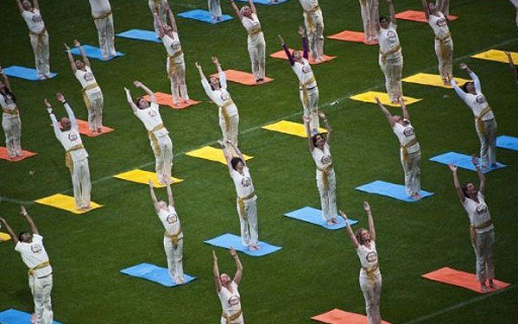 Німеччина, Берлін. Сотні людей виконують вправи йоги під час Всесвітнього фестивалю культури на Олімпійському стадіоні в Берліні. Тисячі людей з усього світу приїхали на фестиваль, яке влаштували на честь 30-річчя руху Раві Шанкара "Мистецтво життя". / © AFP