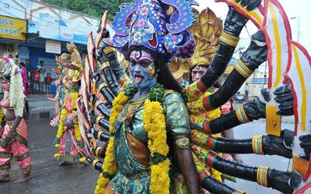 Індія, Хайдарабад. Індійські художники, одягнені у костюми індуїстської богині Махакалі, беруть участь у фінальній процесії під час фестивалю Боналу. Богиню Махакалі вшановують в основному жінки, які здійснюють їй підношення їжею та танцями. / © AFP